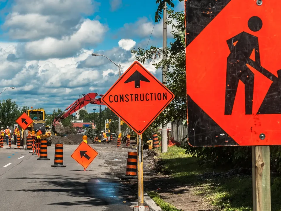 Road construction signs and barrels on a suburban Ontario road.